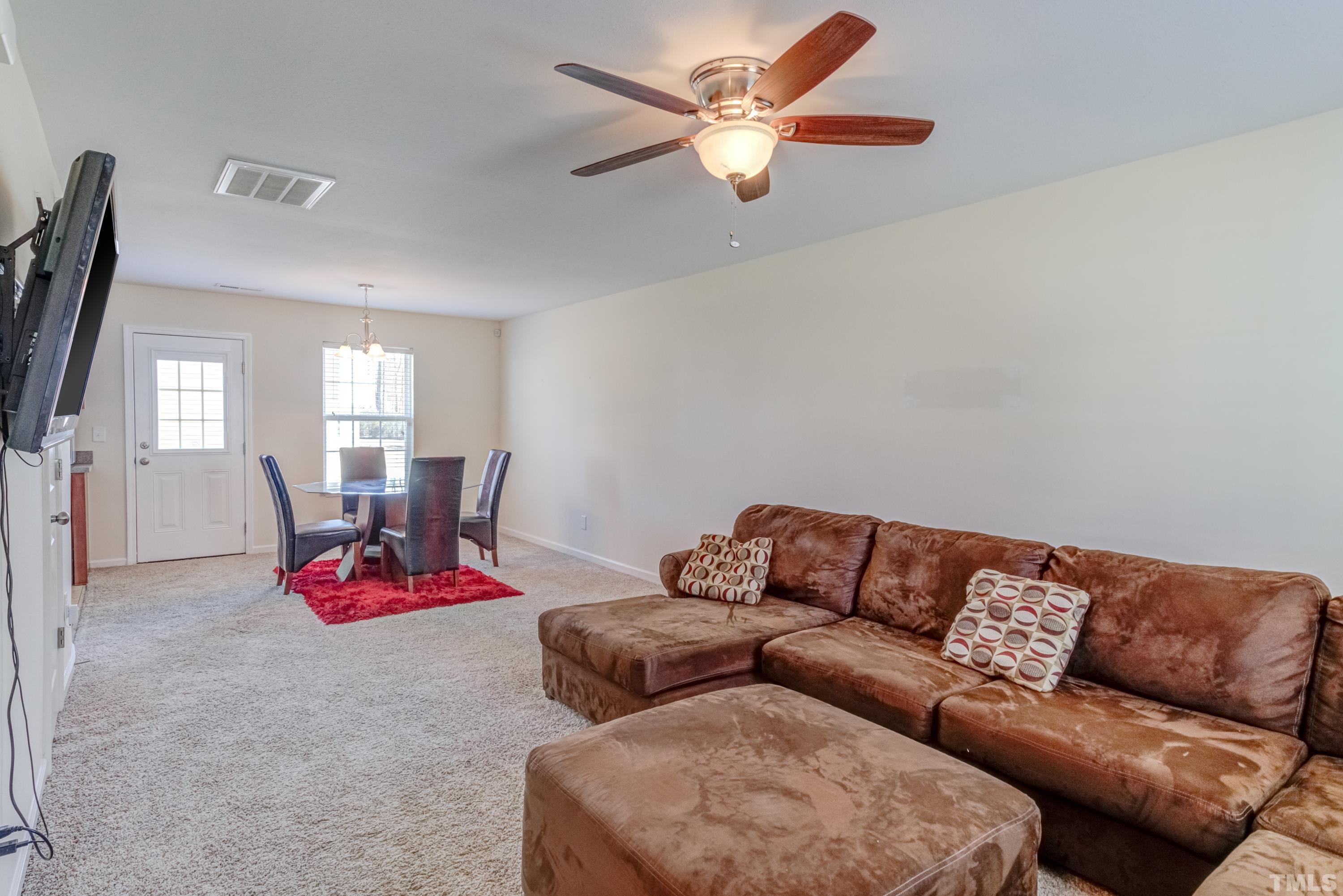 2925 Filbert Street Raleigh, NC 27610 - Photo 4 of 21 a living room with furniture gym equipment and a chandelier