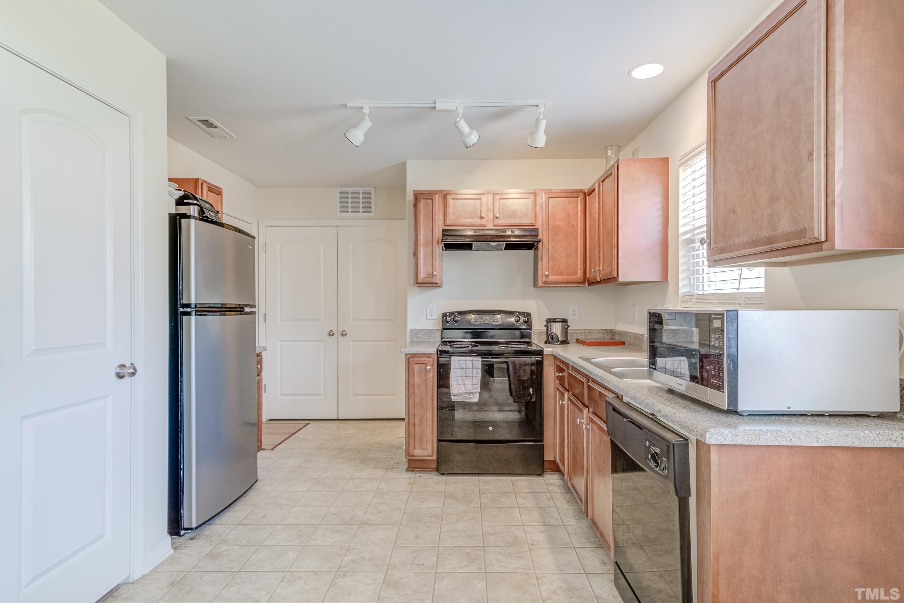 2925 Filbert Street Raleigh, NC 27610 - Photo 7 of 21 a kitchen with stainless steel appliances granite countertop a refrigerator stove and sink