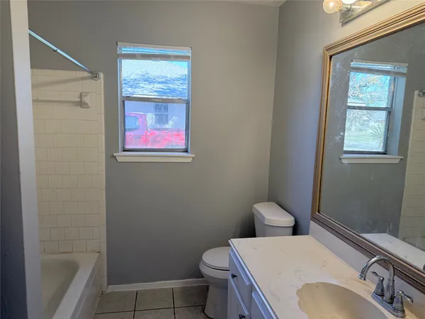 a bathroom with a sink toilet and window