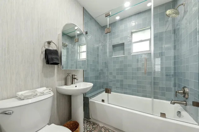 a bathroom with a sink a toilet and shower