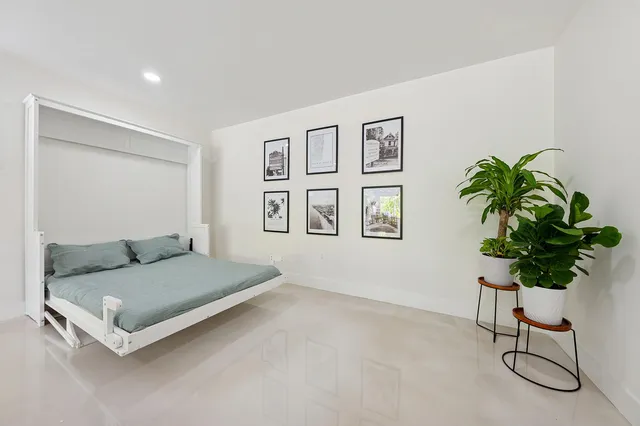 a bedroom with a bed and a potted plant