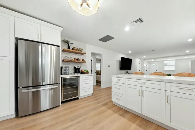 a kitchen with kitchen island white cabinets and stainless steel appliances