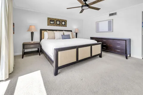 a spacious bedroom with a bed and ceiling fan
