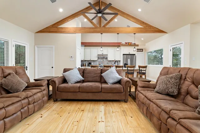 a kitchen with stainless steel appliances a refrigerator a stove a sink dishwasher and white cabinets with wooden floor