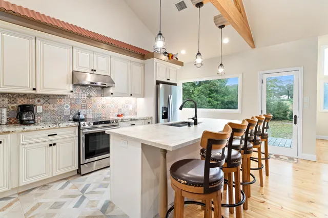 a kitchen with granite countertop a stove sink and cabinets
