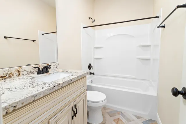a bathroom with a granite countertop sink toilet and shower
