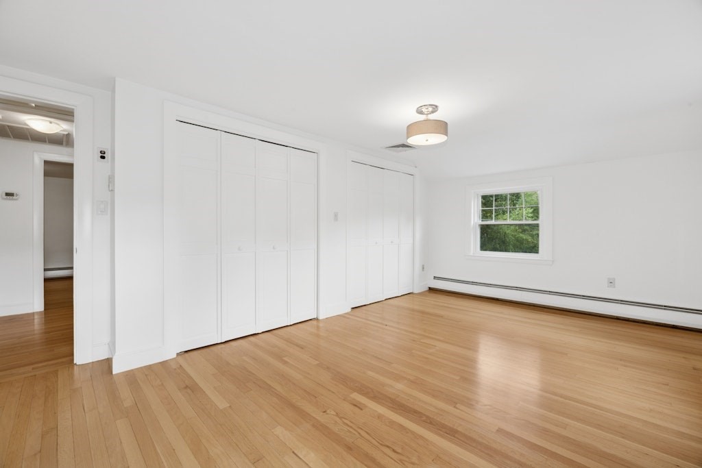 54 Mohawk Drive Acton, MA 01720 - Photo 21 of 42 an empty room with wooden floor chandelier fan and windows