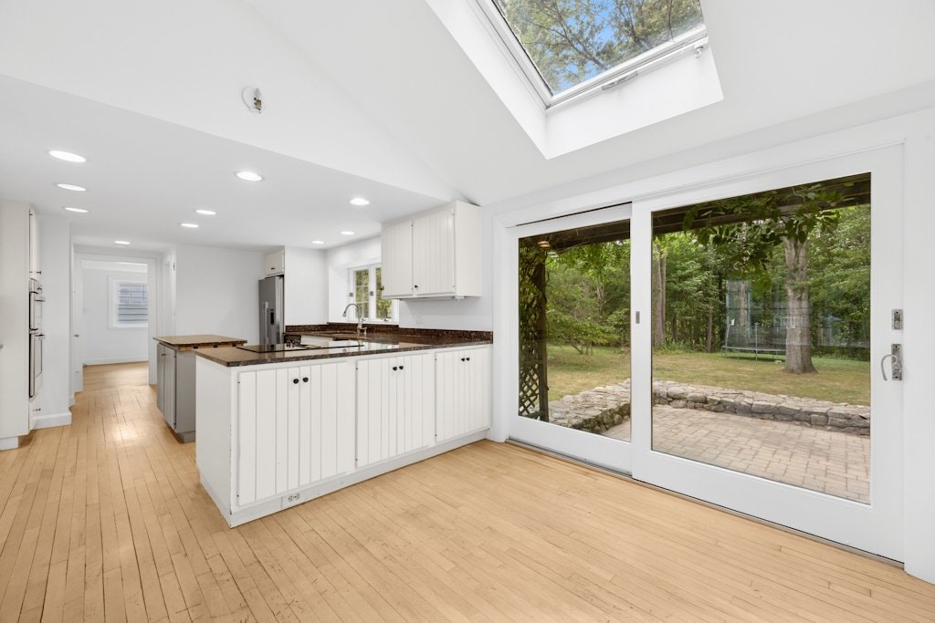 54 Mohawk Drive Acton, MA 01720 - Photo 9 of 42 a open kitchen with white cabinets and wooden floor