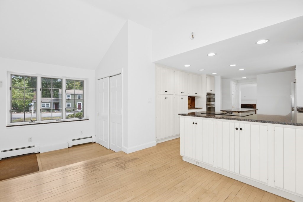 54 Mohawk Drive Acton, MA 01720 - Photo 10 of 42 a large white kitchen with kitchen island a sink wooden floor and a large window