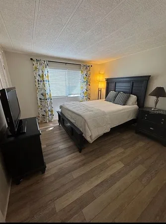 a spacious bedroom with a bed and wooden floor