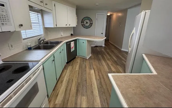 a very nice looking room with wooden floor and cabinets