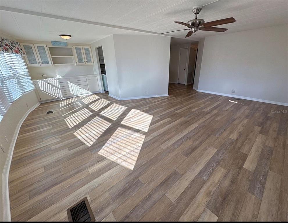 3301 Alt 19, Unit 162 Dunedin, FL 34698 - Photo 5 of 23 a view of an empty room with wooden floor and a ceiling fan