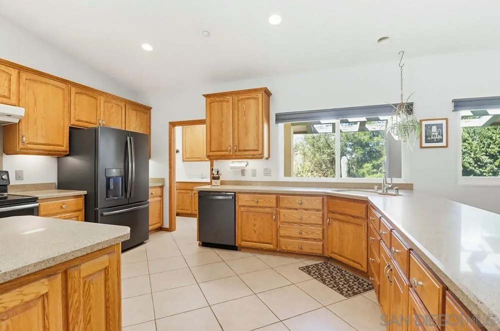 359 Galloway Valley Road Alpine, CA 91901 - Photo 8 of 50 a kitchen with a sink a counter top space stainless steel appliances a large window and cabinets
