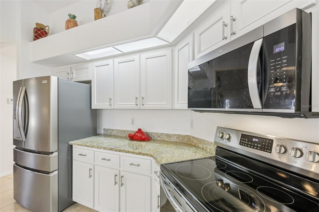 257 Medalist Road Rotonda West, FL 33947 - Photo 11 of 32 a kitchen with a stove and a refrigerator