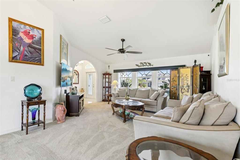 257 Medalist Road Rotonda West, FL 33947 - Photo 6 of 32 a living room with furniture a chandelier and a fireplace