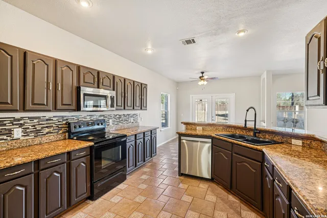 a kitchen with stainless steel appliances granite countertop a sink stove and refrigerator