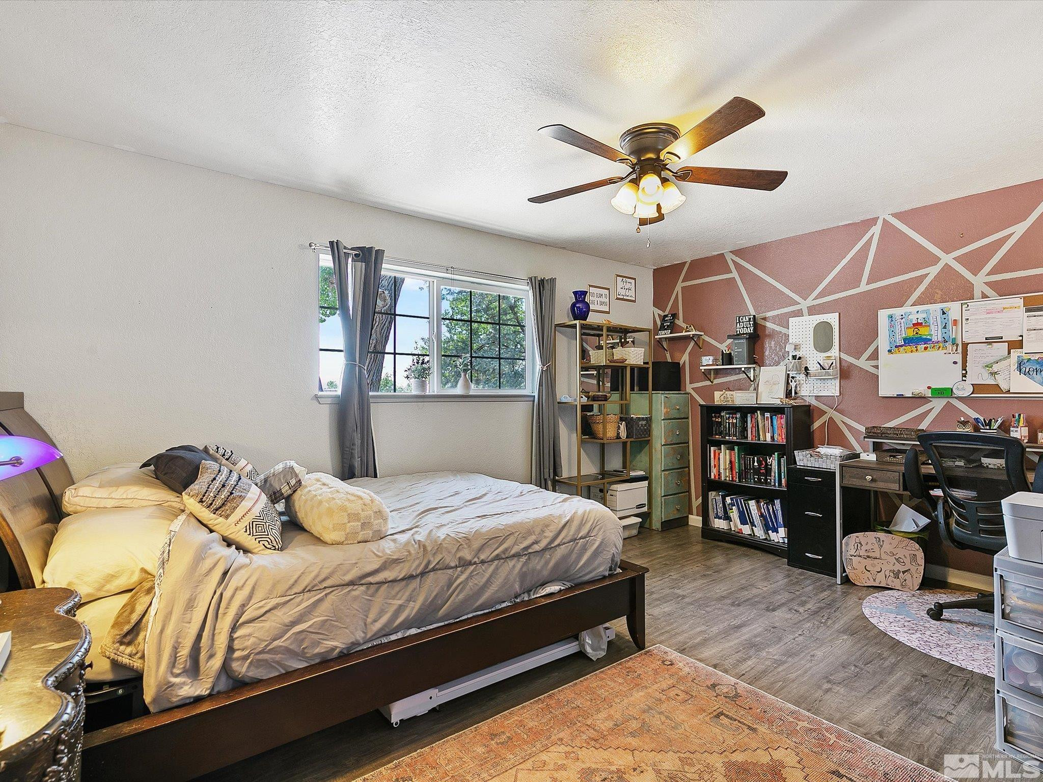 660 Northview Drive Fallon, NV 89406 - Photo 22 of 33 a bedroom with a bed a chandelier and window