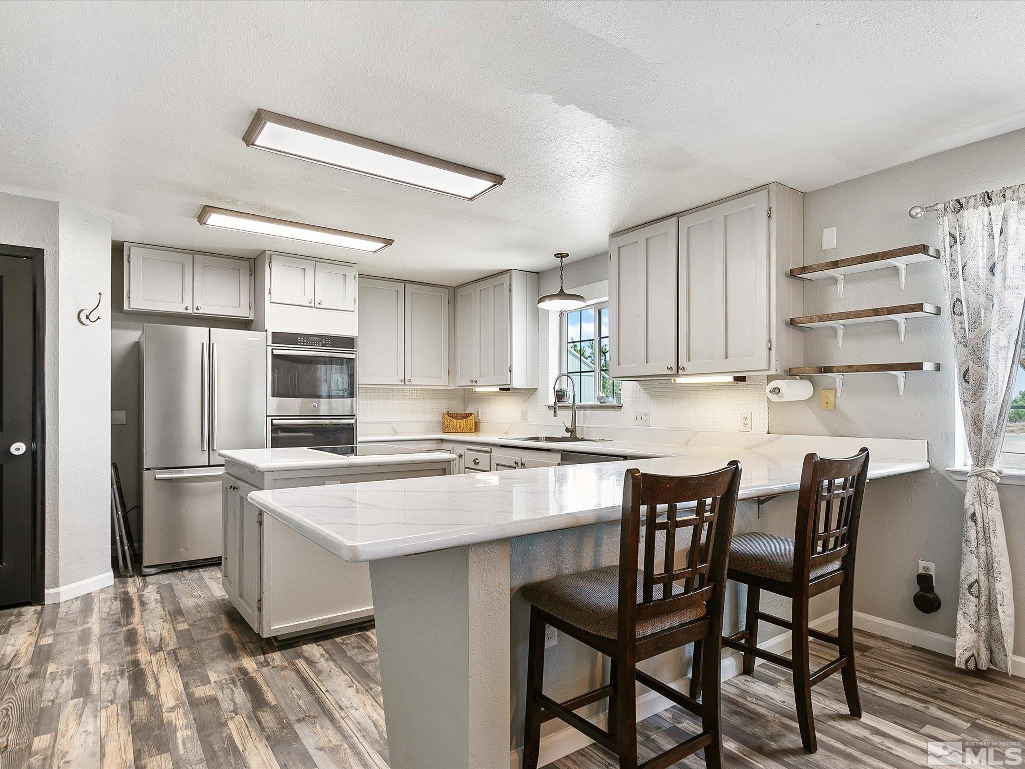 660 Northview Drive Fallon, NV 89406 - Photo 7 of 33 a kitchen with stainless steel appliances a dining table chairs refrigerator and cabinets
