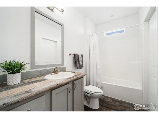 a bathroom with a granite countertop sink toilet a large mirror and shower