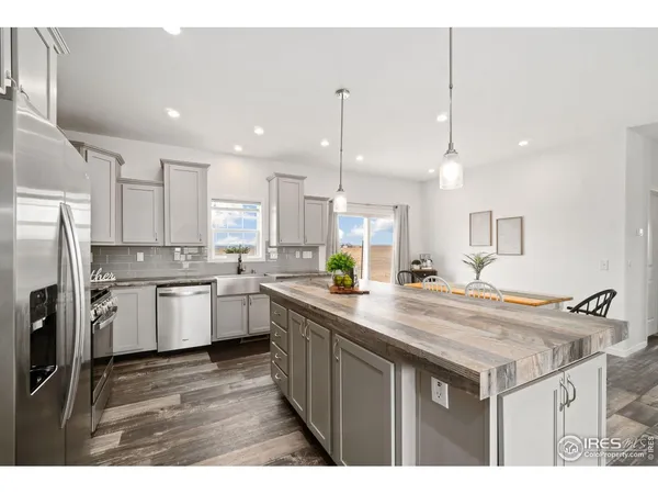 a kitchen with a sink a counter top space stainless steel appliances and cabinets