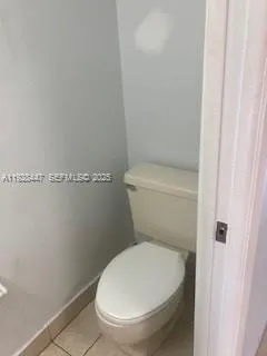 a white toilet sitting next to a shower