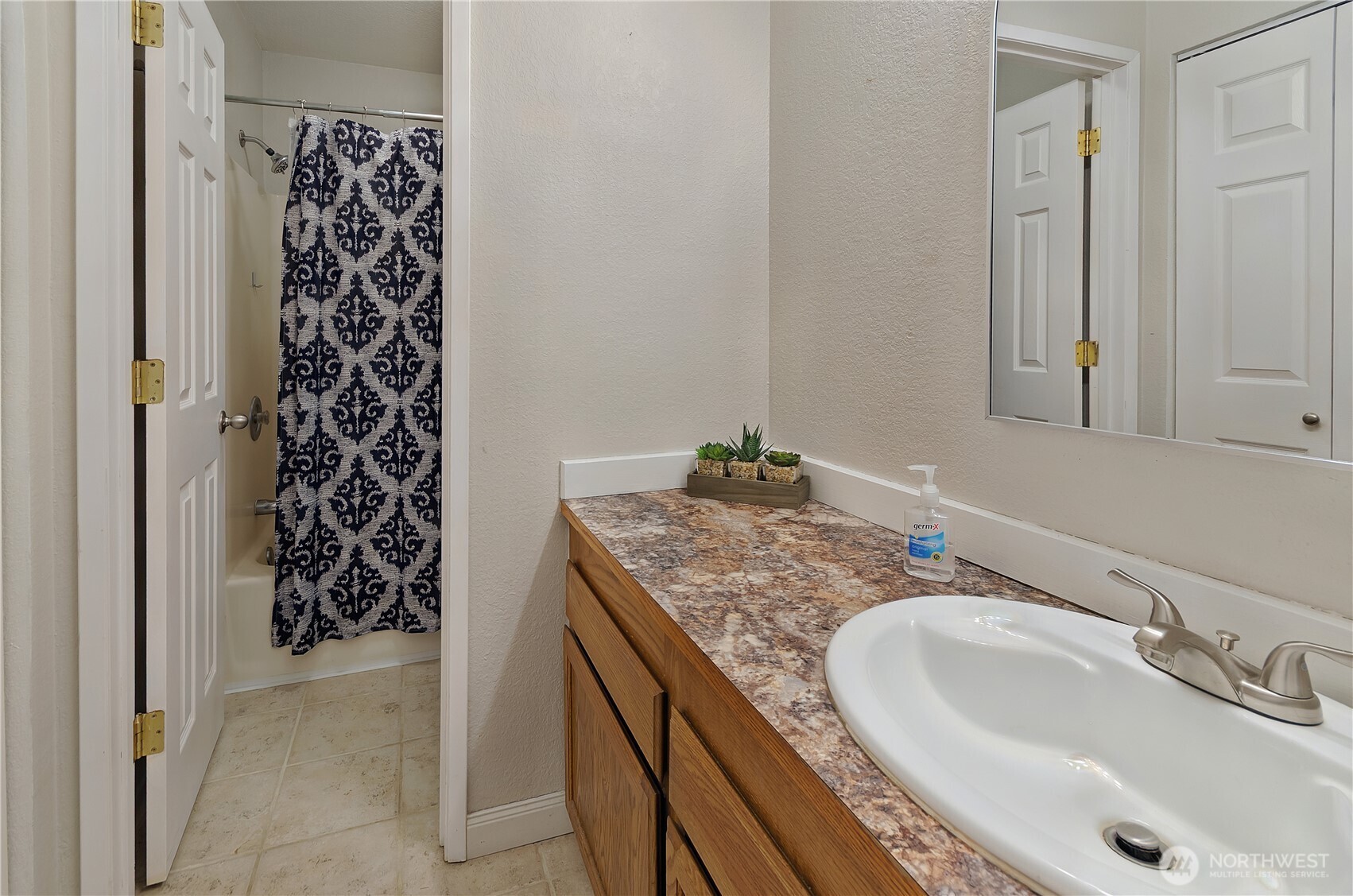 5214 78th Court Southwest Olympia, WA 98512 - Photo 17 of 27 a bathroom with a granite countertop sink a mirror and shower