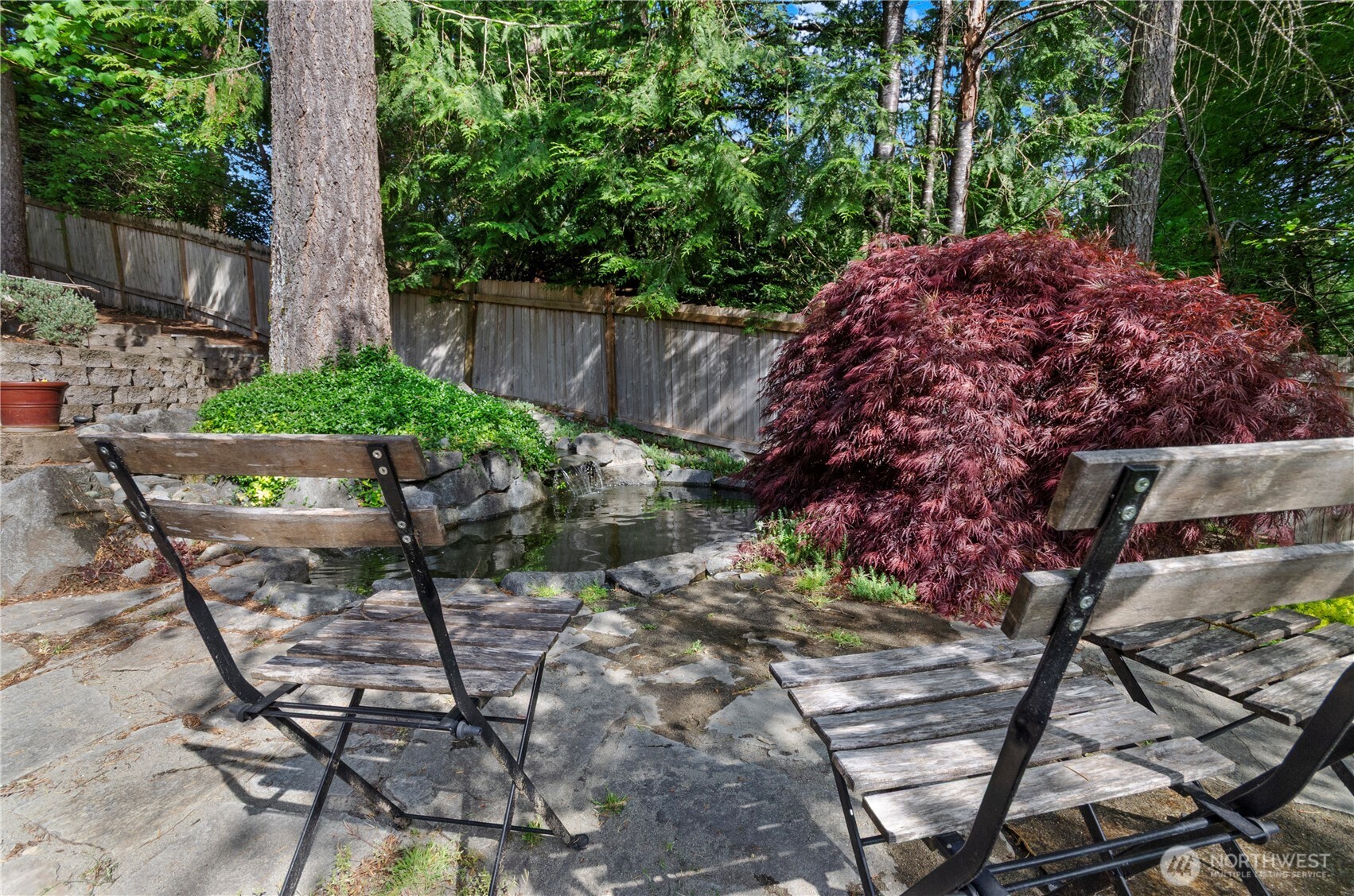 5214 78th Court Southwest Olympia, WA 98512 - Photo 21 of 27 a wooden bench sitting in backside of a house with a garden