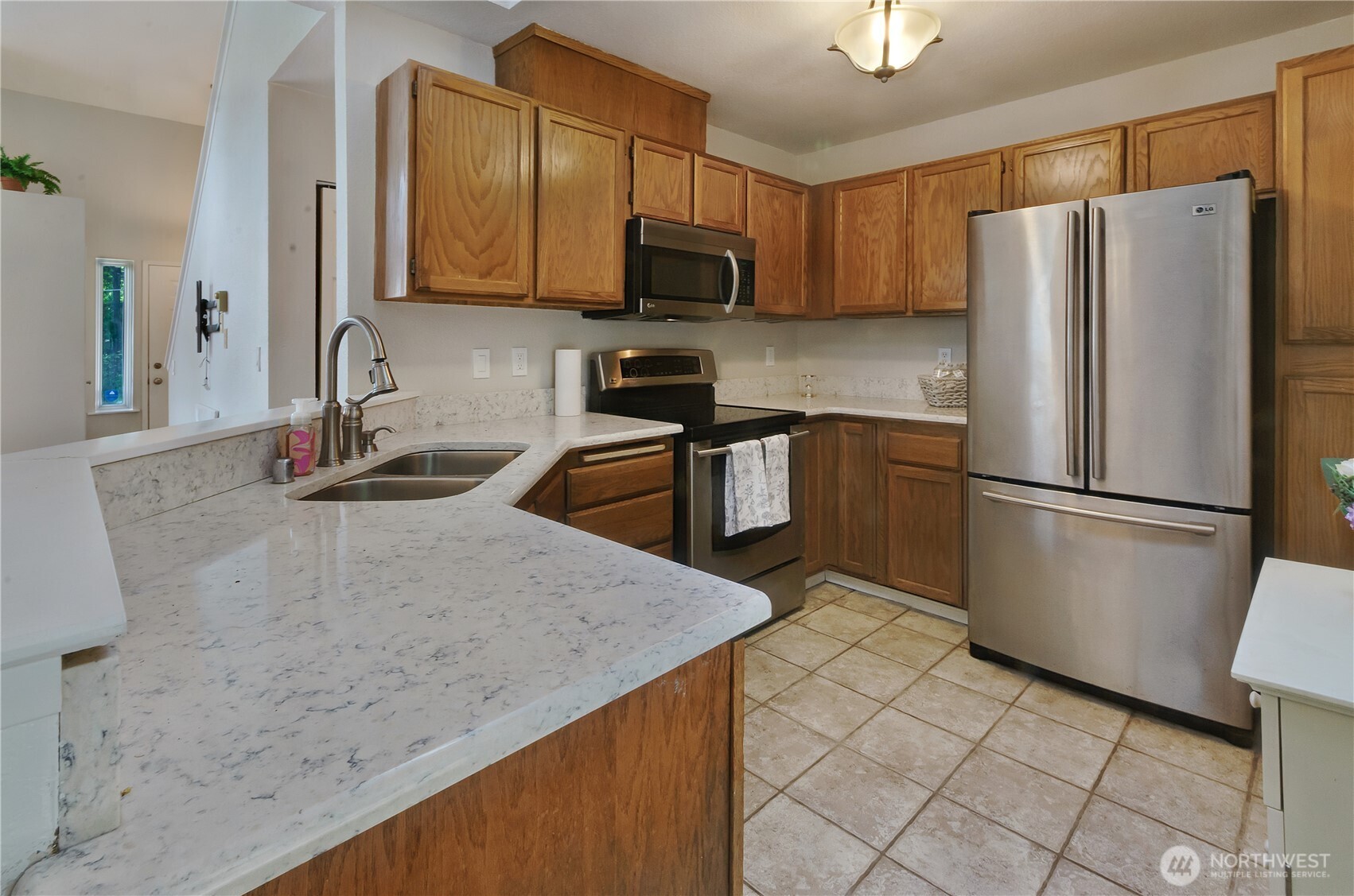 5214 78th Court Southwest Olympia, WA 98512 - Photo 7 of 27 a kitchen with granite countertop a refrigerator a stove a sink a microwave and island