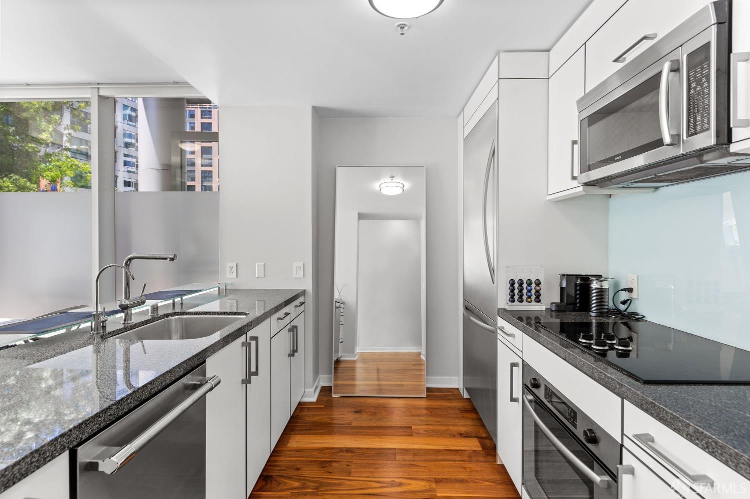 333 Main Street, Unit 2A San Francisco, CA 94105 - Photo 7 of 24 a kitchen with stainless steel appliances granite countertop a sink and stove