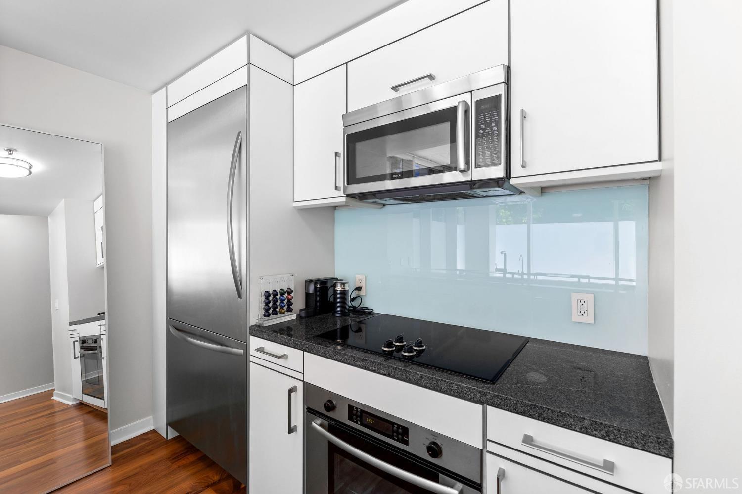 333 Main Street, Unit 2A San Francisco, CA 94105 - Photo 9 of 24 a kitchen with stainless steel appliances granite countertop a refrigerator and a microwave