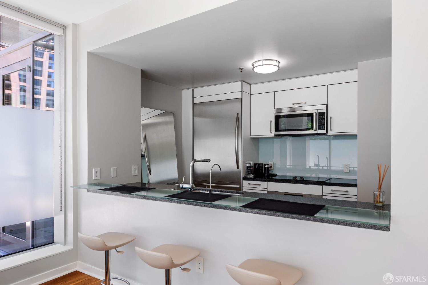 333 Main Street, Unit 2A San Francisco, CA 94105 - Photo 10 of 24 a kitchen with stainless steel appliances a sink a stove a microwave a refrigerator and cabinets