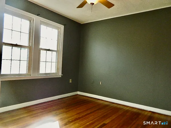 a view of an empty room with wooden floor