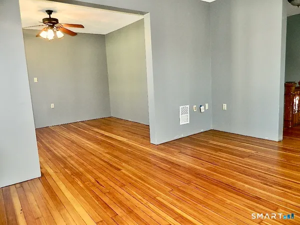a view of empty room with wooden floor