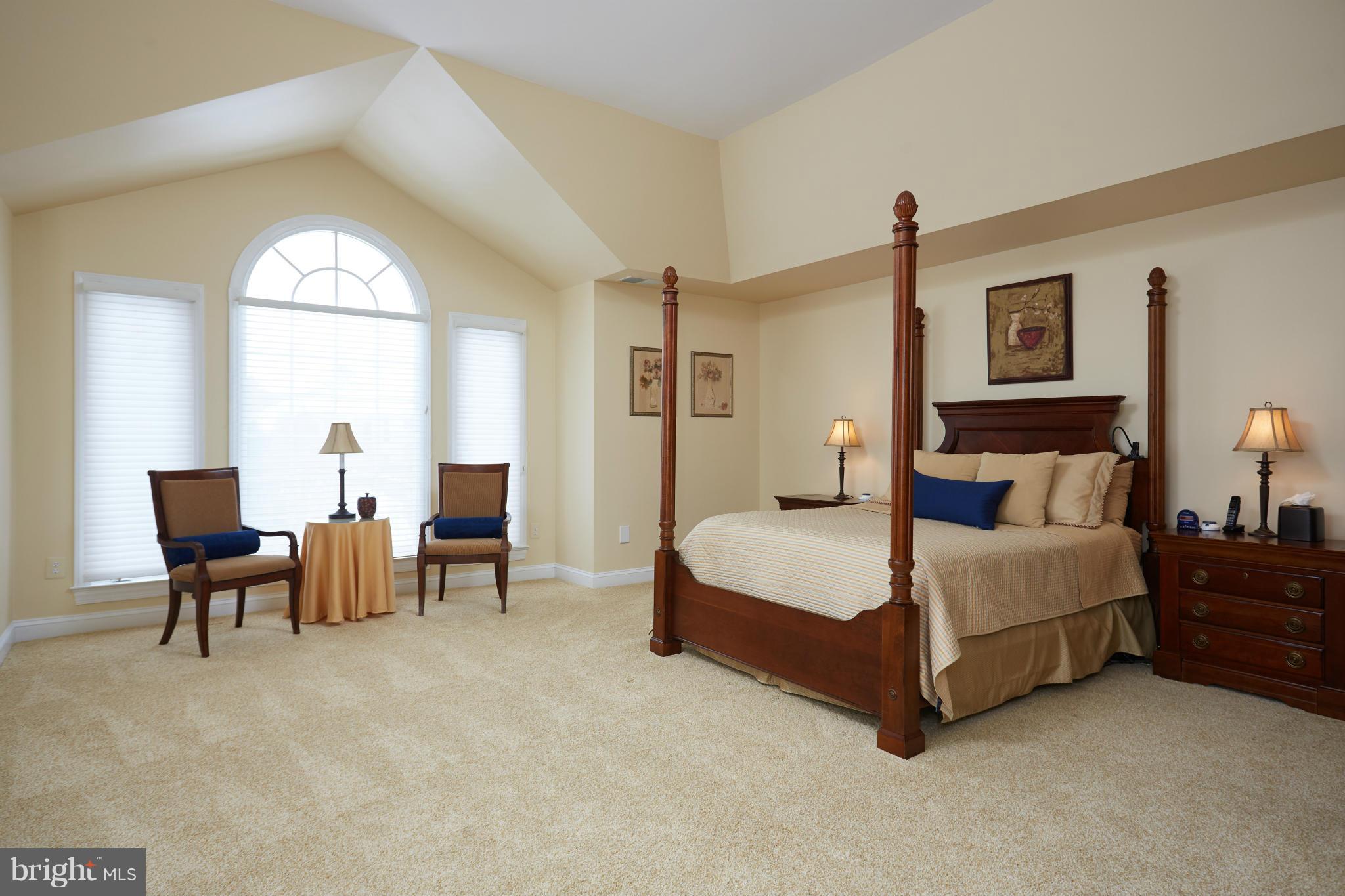 12636 Greenbriar Road Potomac, MD 20854 - Photo 15 of 30 a spacious bedroom with a bed and a chandelier