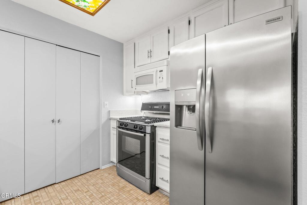 2202 Martinique Lane Oxnard, CA 93035 - Photo 17 of 39 a kitchen with stainless steel appliances granite countertop a refrigerator a sink and white cabinets