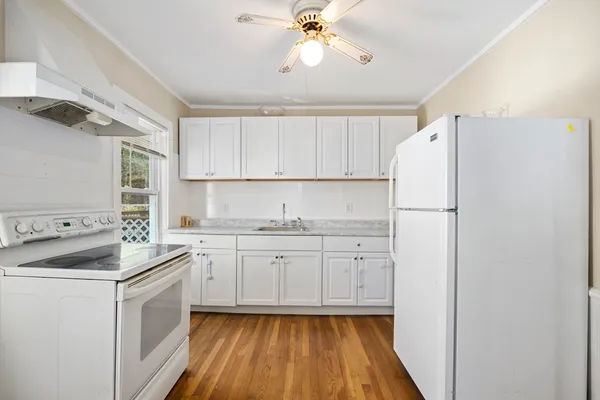 a kitchen with sink cabinets and white appliances