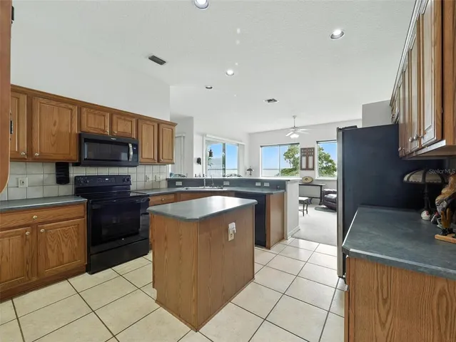a kitchen with stainless steel appliances granite countertop a stove top oven a sink dishwasher and a refrigerator