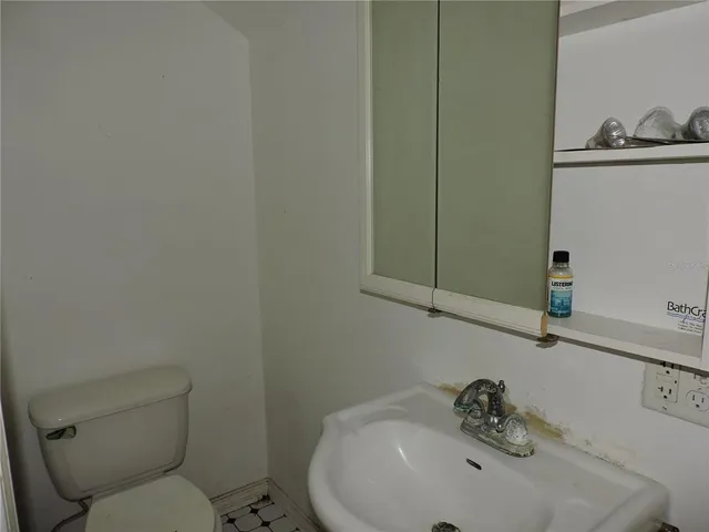 a bathroom with a sink a toilet and mirror