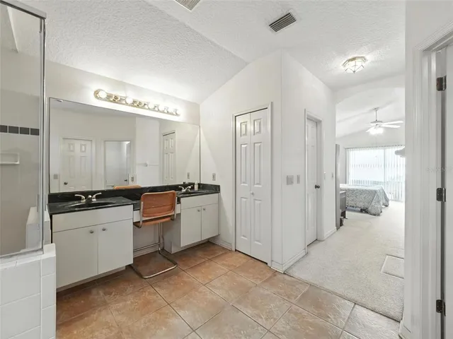 a large bathroom with a glass door shower a sink and a mirror