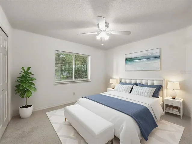 a bedroom with a balcony a bed and a potted plant