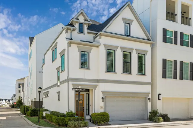 a kitchen that has a lot of white cabinets and stainless steel appliances