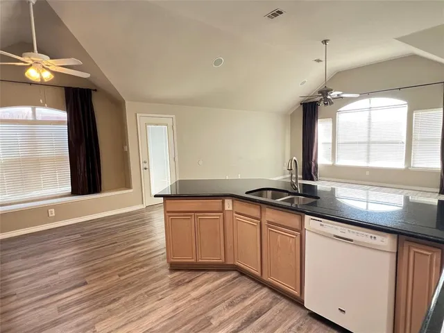 a kitchen with granite countertop a sink and cabinets