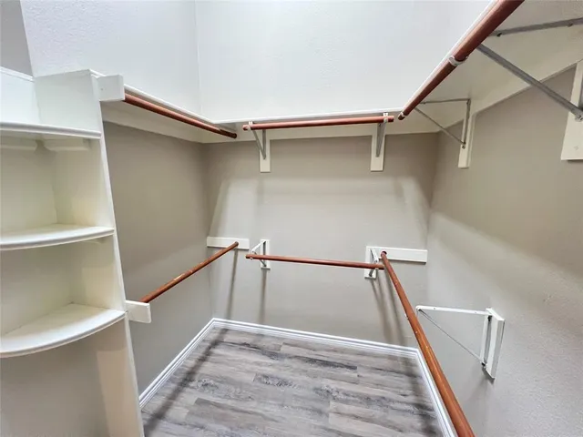 a view of walk in closet with empty racks
