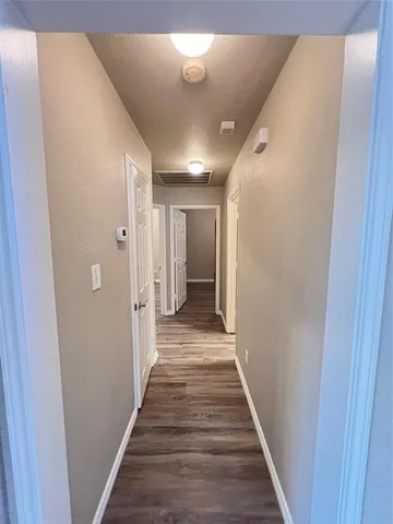 a view of a hallway with wooden floor