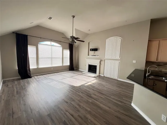 a view of empty room with a fireplace and wooden floor