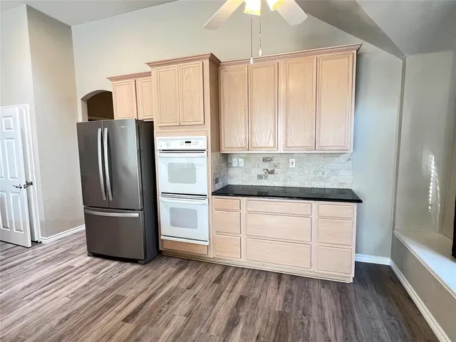 a kitchen with stainless steel appliances granite countertop a refrigerator and a stove top oven