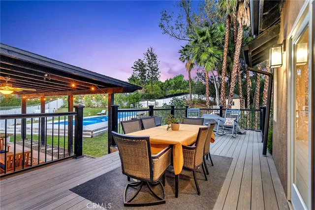 a view of a patio with table and chairs with wooden floor and fence