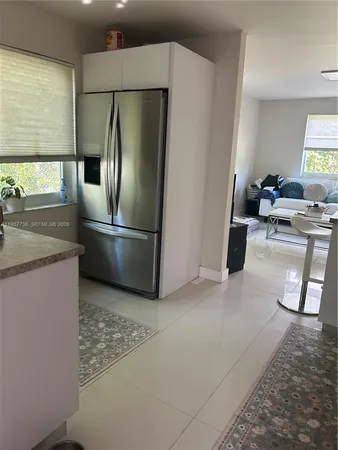 a kitchen with stainless steel appliances granite countertop a refrigerator a sink a stove and a refrigerator