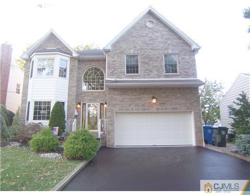 34 West Hill Road Colonia, NJ 07067 - Photo 1 of 25 a front view of a house with a garden and garage