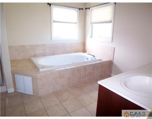 34 West Hill Road Colonia, NJ 07067 - Photo 13 of 25 a bath tub sitting in a bathroom next to a window